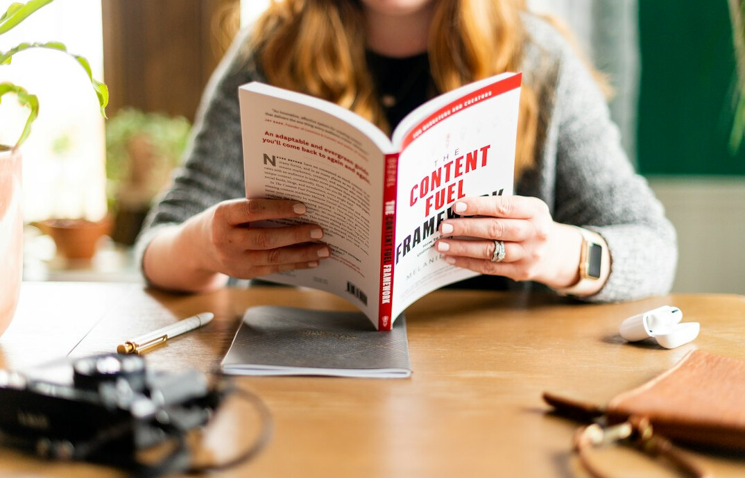 woman reading book at desk