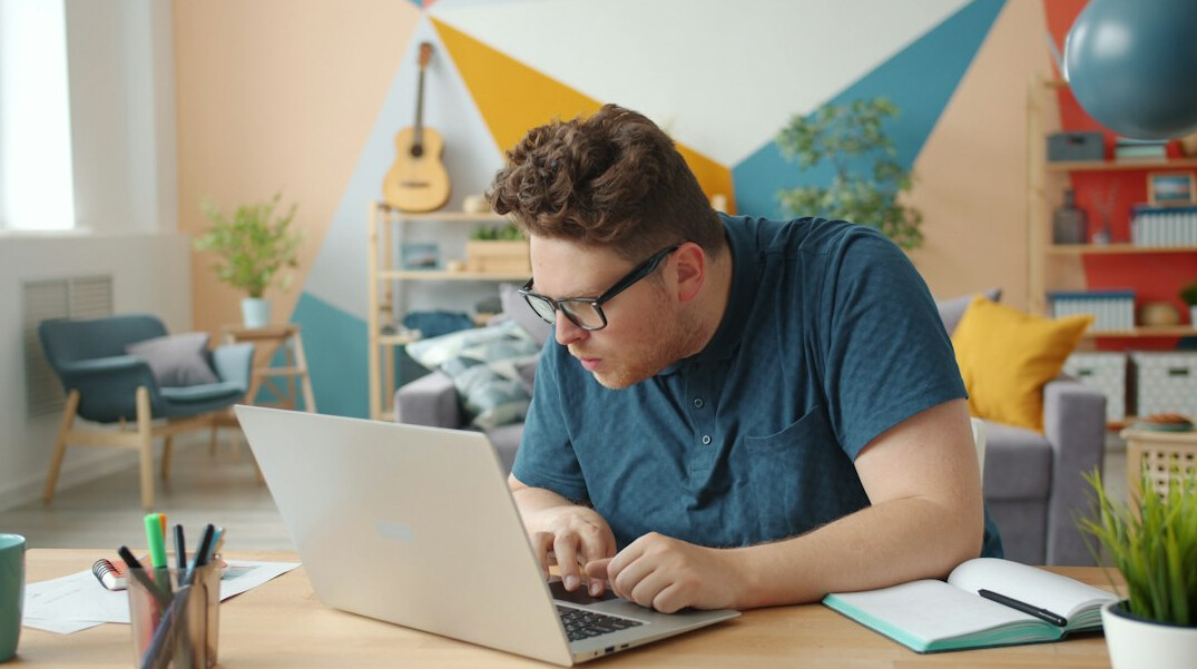 adult studying with laptop at home desk